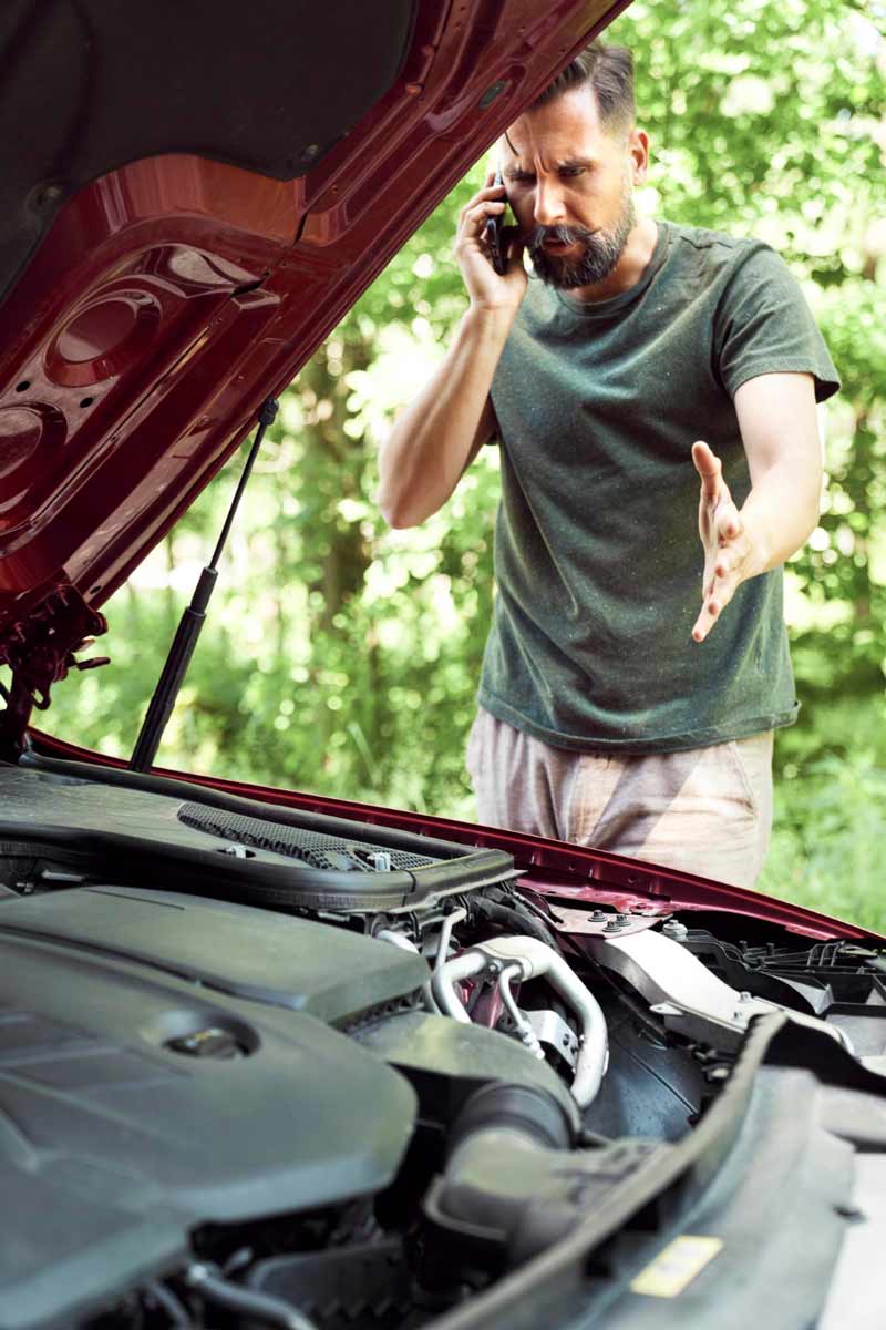 Junger Mann prüft Getriebeschaden bei Schrottauto Ankauf Mayen